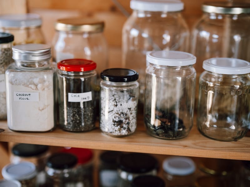 Container storage at a kitchen pantry with different types of food items in jars and bottles at home